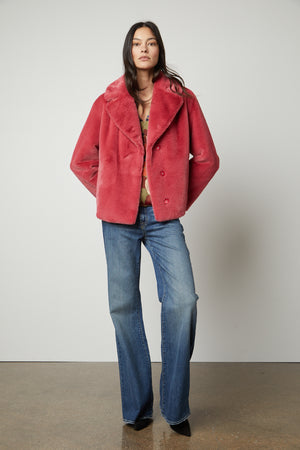 The model is looking chic in a pink Velvet by Graham & Spencer RAQUEL FAUX LUX FUR JACKET, perfect for the cold weather.