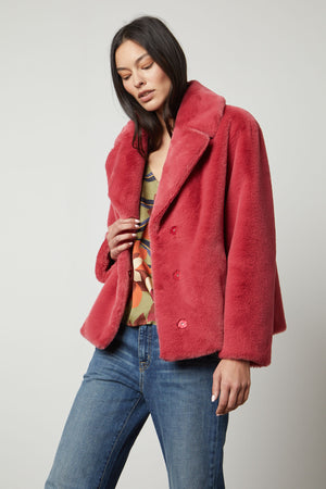 The model looks chic and cozy in her pink Velvet by Graham & Spencer RAQUEL FAUX LUX FUR JACKET.