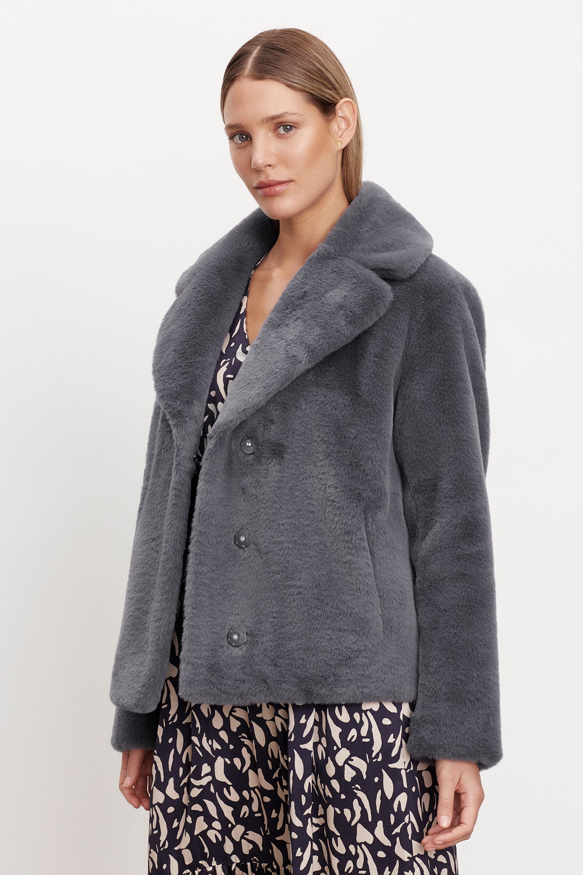   The model is wearing a grey Velvet by Graham & Spencer RAQUEL FAUX LUX FUR JACKET, perfect for cold weather. 