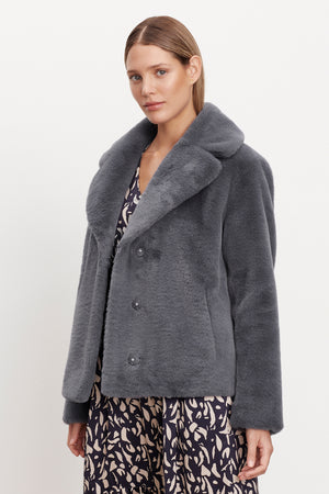 The model is wearing a grey Velvet by Graham & Spencer RAQUEL FAUX LUX FUR JACKET, perfect for cold weather.