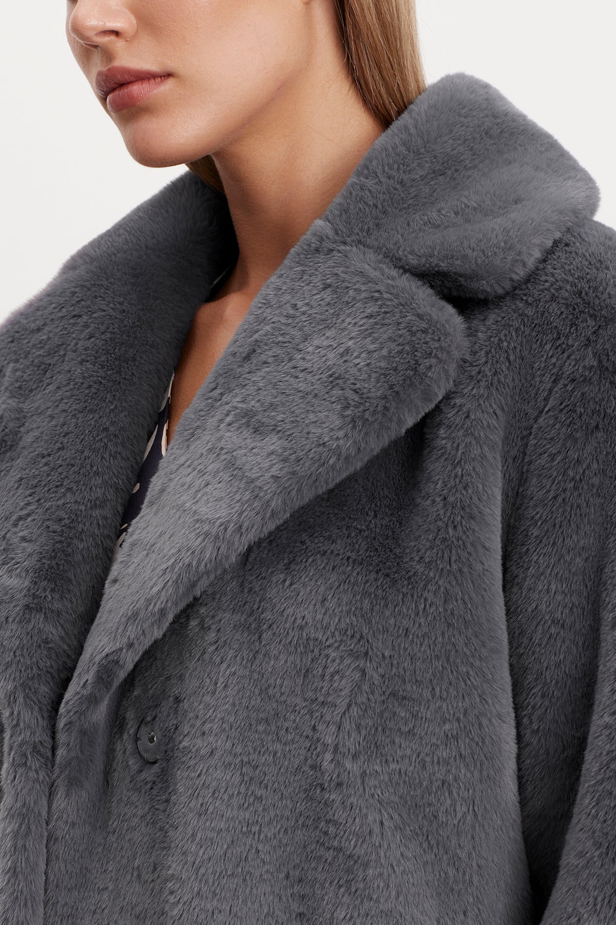   A woman wearing a grey Velvet by Graham & Spencer RAQUEL FAUX LUX FUR JACKET for cold weather. 