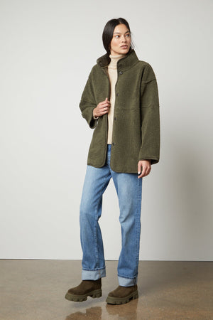 A man wearing an Albany Lux Sherpa Reversible Jacket by Velvet by Graham & Spencer.
