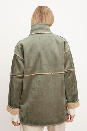 The back view of a woman wearing an Albany Lux Sherpa Reversible Jacket by Velvet by Graham & Spencer.