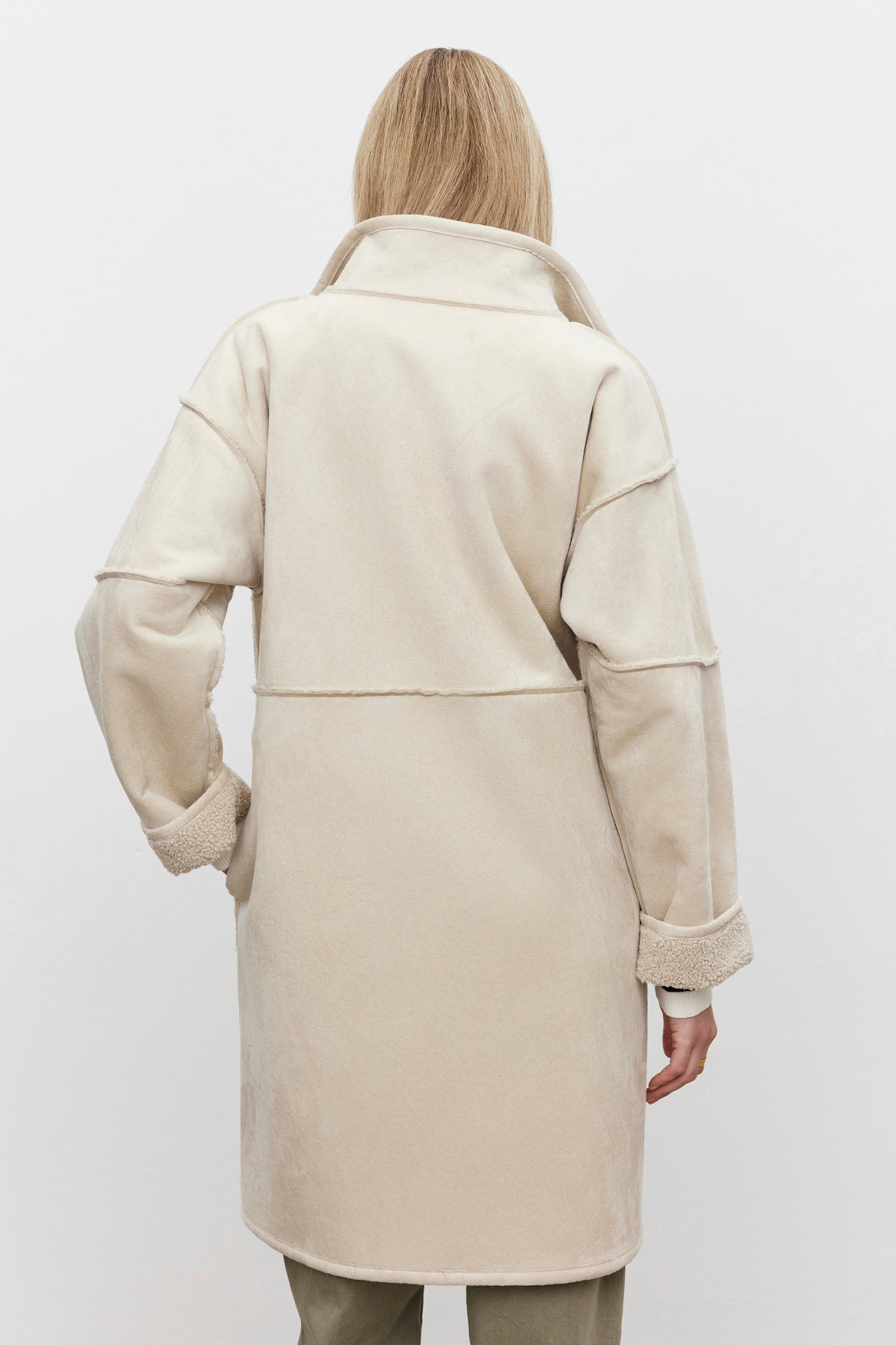   A person wearing a Velvet by Graham & Spencer CARA LUXE SHERPA REVERSIBLE JACKET in cream-colored faux suede with a high collar, viewed from the back against a plain white background. 