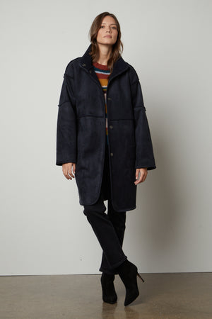 A woman wearing a Velvet by Graham & Spencer CARA LUX SHERPA REVERSIBLE JACKET and striped tee.