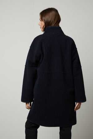 The back view of a woman wearing a Velvet by Graham & Spencer CARA LUX SHERPA REVERSIBLE JACKET.