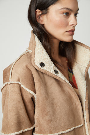 The model is wearing a tan Velvet by Graham & Spencer KELLY LUX SHERPA REVERSIBLE JACKET.