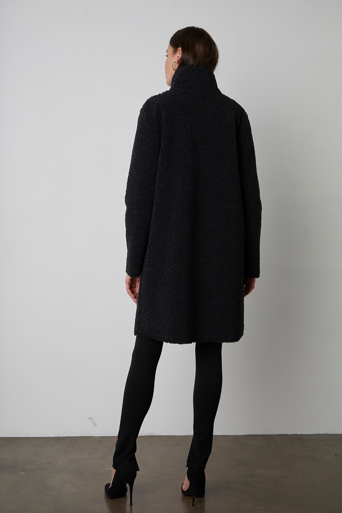 Mirabel Faux Lux Sherpa Reversible Coat in black with black leggings and black heels full length back view-26683697234113