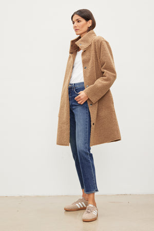A woman wearing the MIRABEL FAUX LUX SHERPA REVERSIBLE COAT by Velvet by Graham & Spencer and jeans.