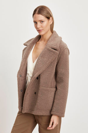 The model is wearing the YOKO LUX SHERPA OVERSIZED JACKET by Velvet by Graham & Spencer, which is perfect for winter.