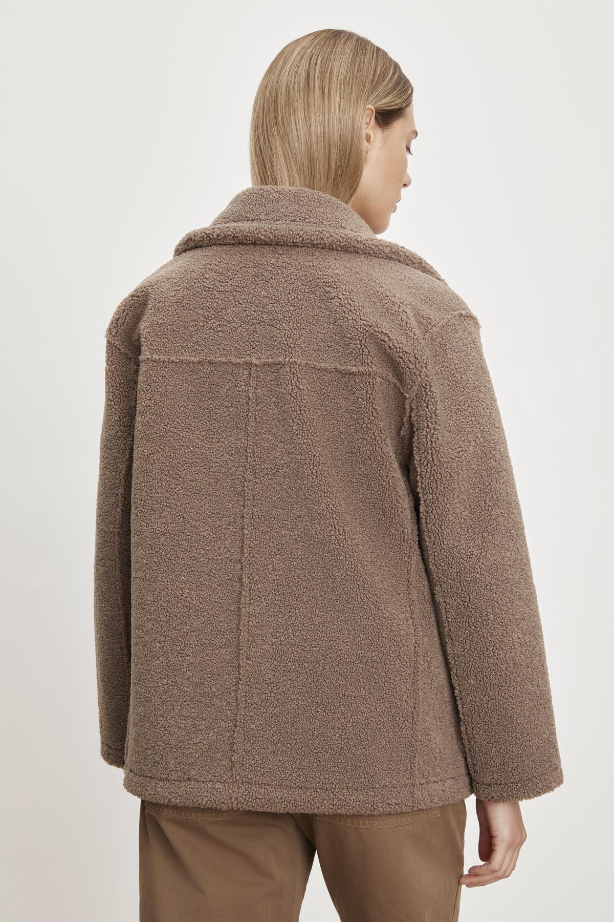   The back view of a woman wearing the YOKO LUX SHERPA OVERSIZED JACKET by Velvet by Graham & Spencer. 