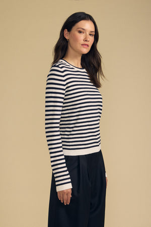 Side view of ROXY Luxe Cotton Cashmere Crew Neck Sweater showcasing navy and white stripes, modeled against beige background