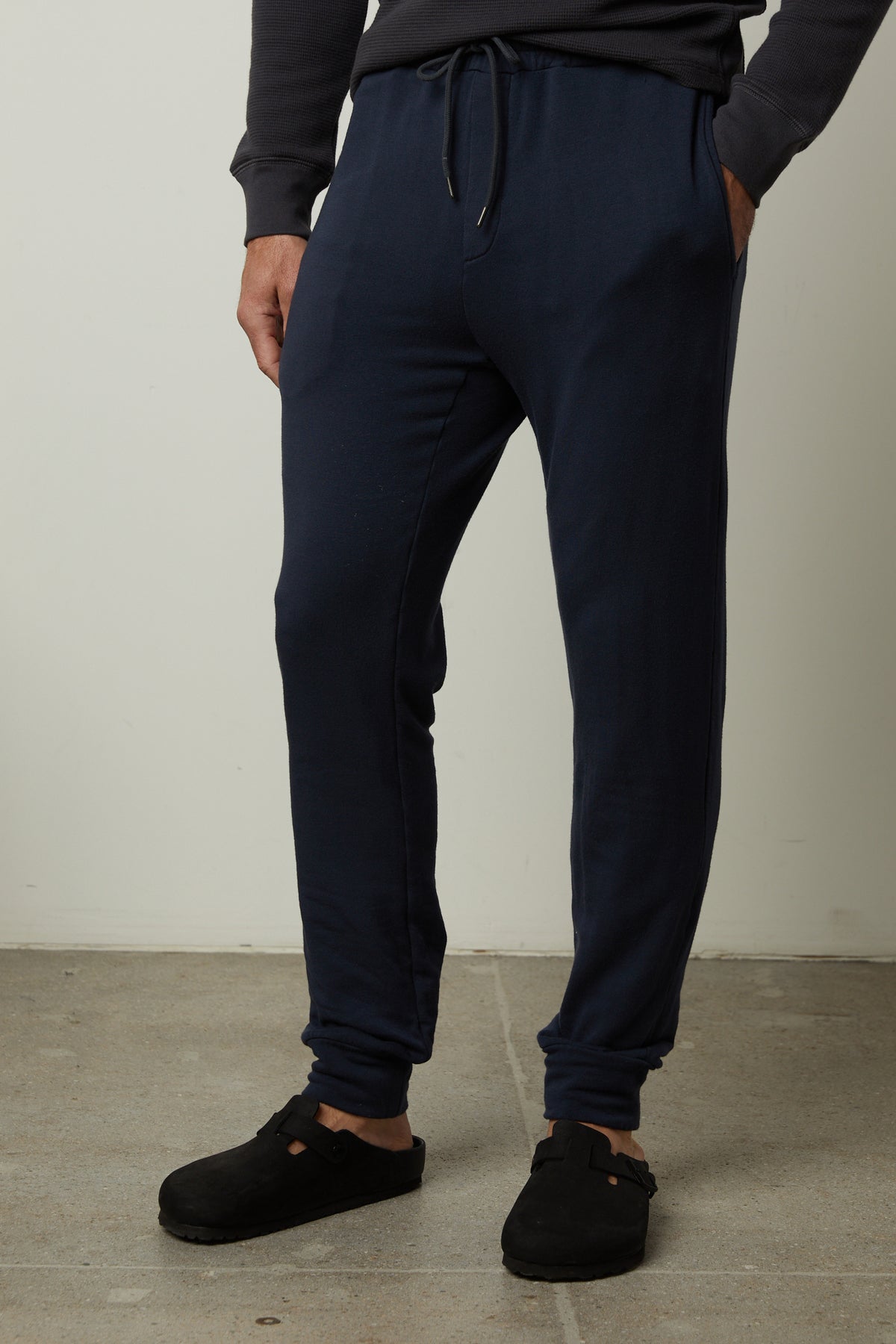 The man is wearing Velvet by Graham & Spencer medium-weight navy Crosby Luxe Fleece Jogger sweatpants for workouts.-35662741176513