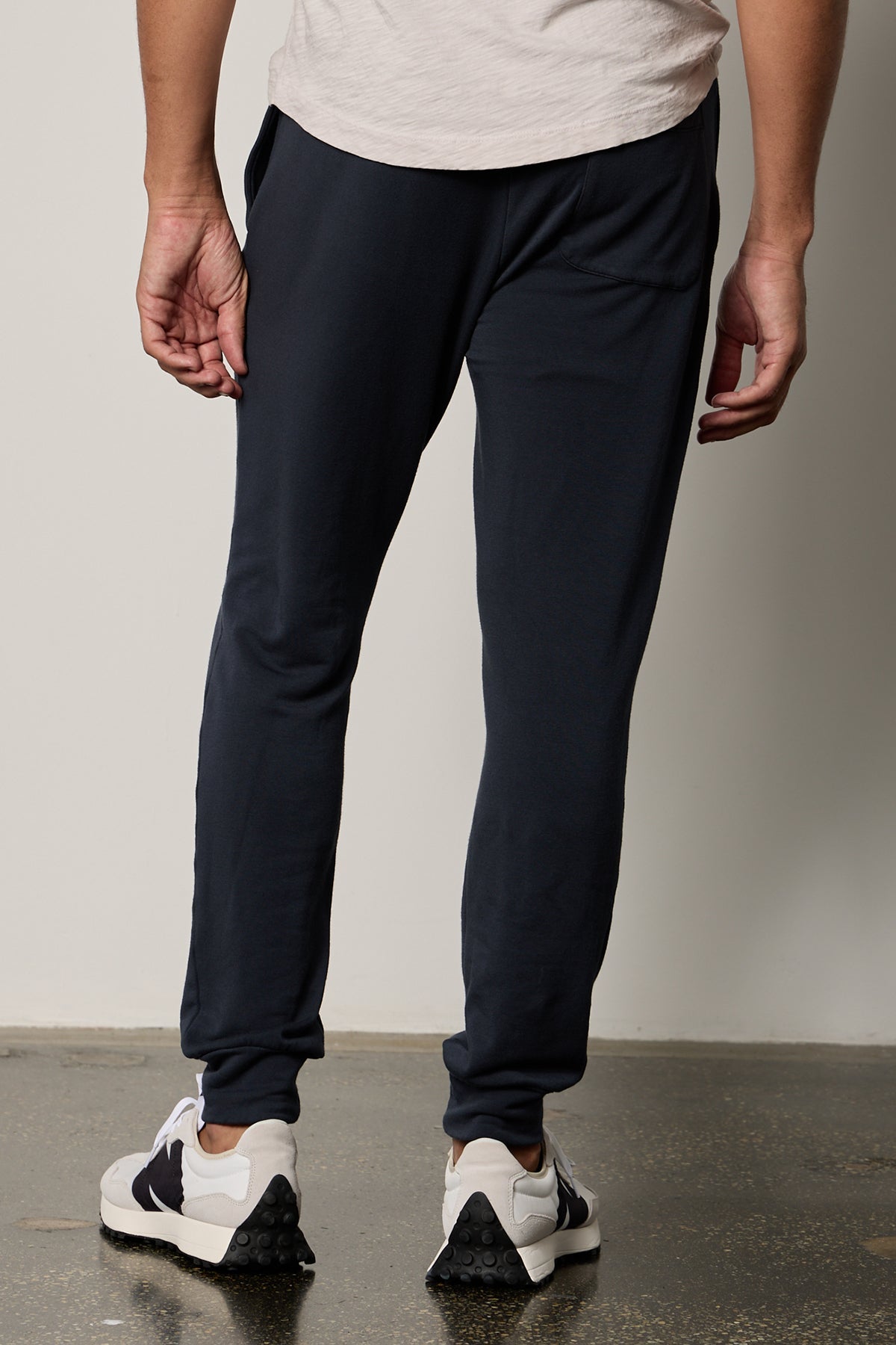 The back view of a man wearing Velvet by Graham & Spencer navy joggers with tailored design details, the CROSBY LUXE FLEECE JOGGER.-26630189088961