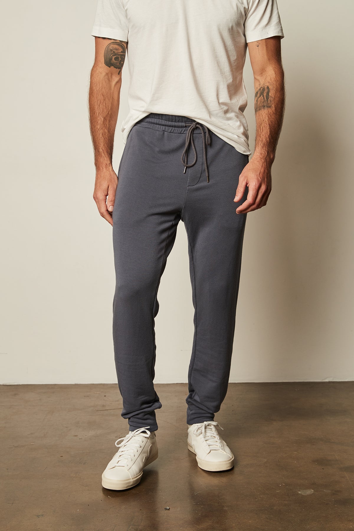   A man wearing Crosby Luxe Fleece Jogger sweatpants by Velvet by Graham & Spencer and a white t-shirt for workouts. 