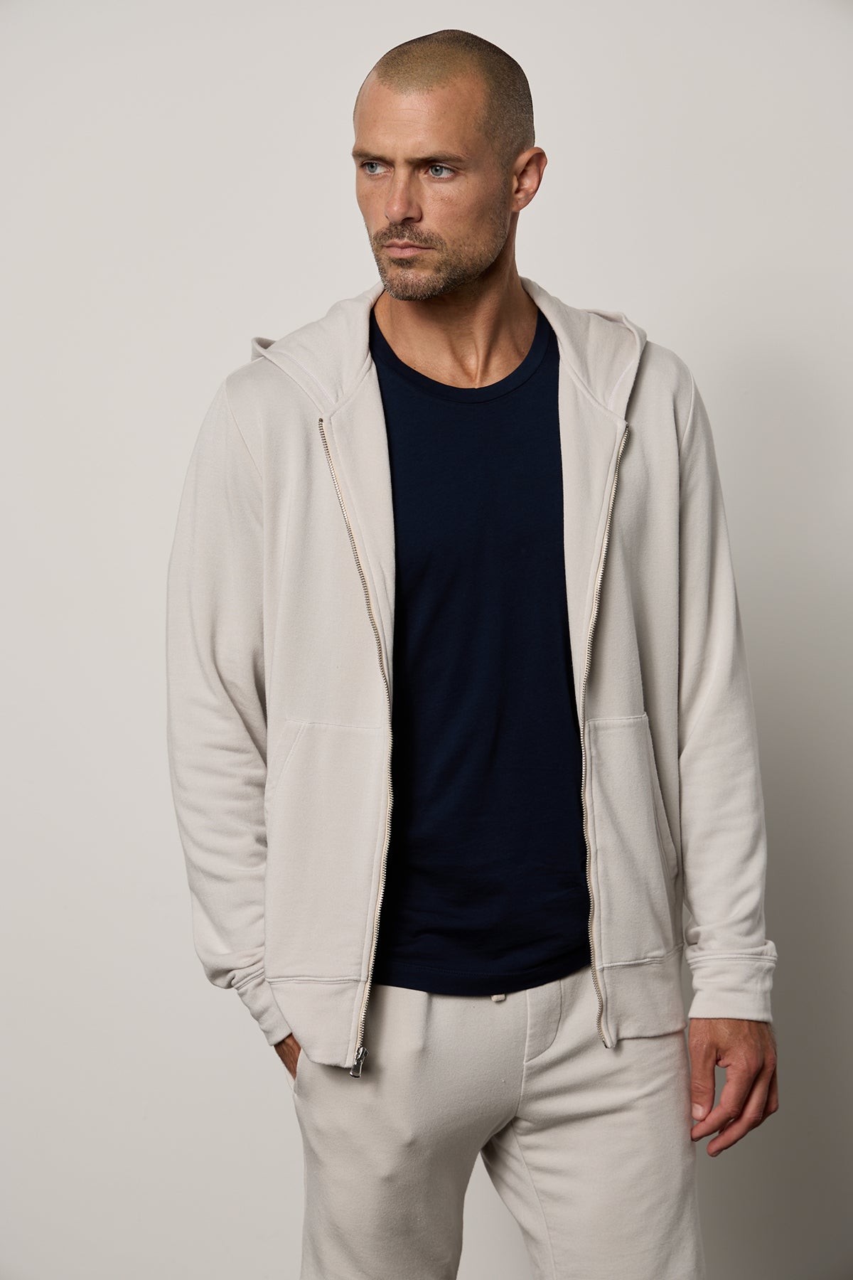  A Velvet by Graham & Spencer Rodan Luxe Fleece Zip Hoodie-wearing man, effortlessly rocks a casual gym-class inspired look with matching pants. 