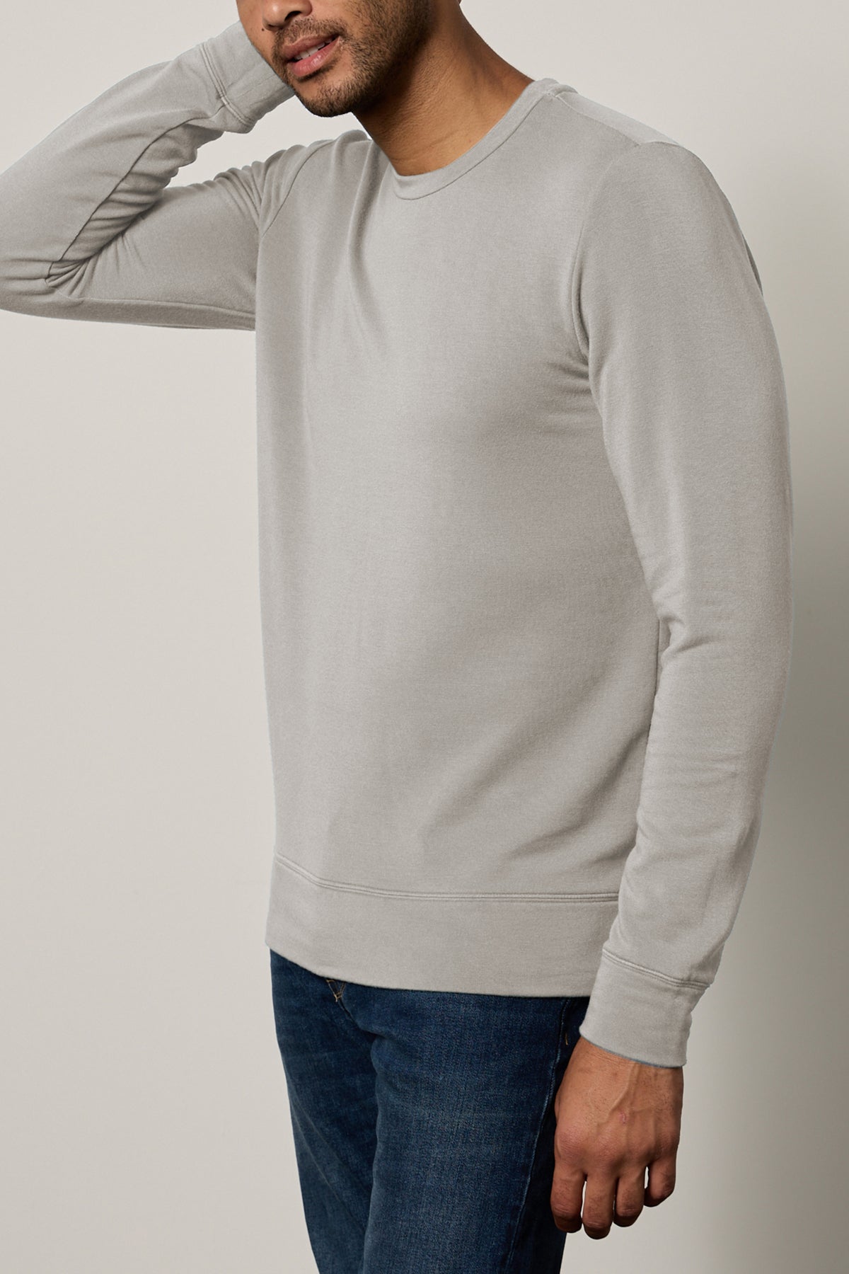   A person wearing the SOREN PULLOVER by Velvet by Graham & Spencer and jeans is standing against a plain background, with their head partially out of the frame. 