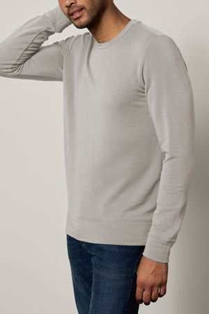 A person wearing the SOREN PULLOVER by Velvet by Graham & Spencer and jeans is standing against a plain background, with their head partially out of the frame.