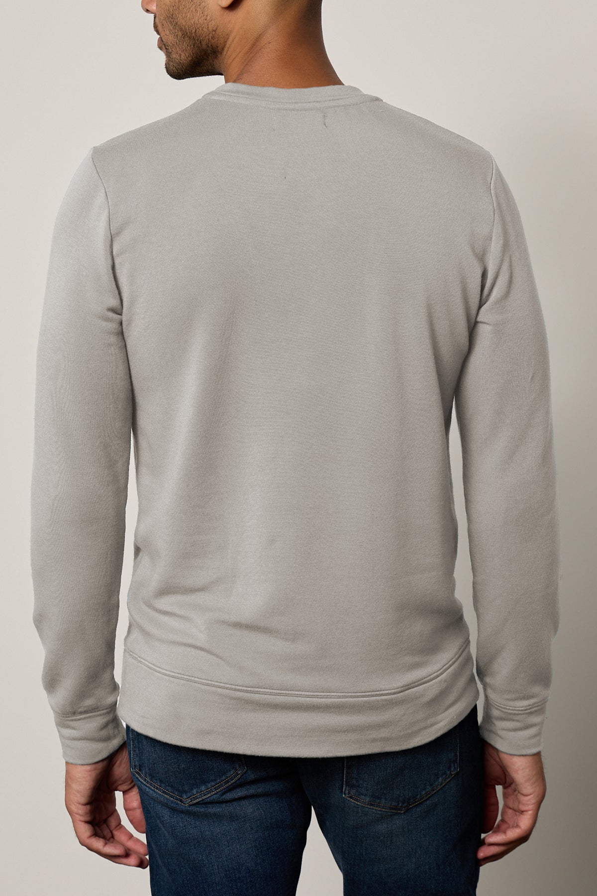   A person is shown from the back wearing the Velvet by Graham & Spencer's SOREN PULLOVER in light gray paired with dark jeans. 