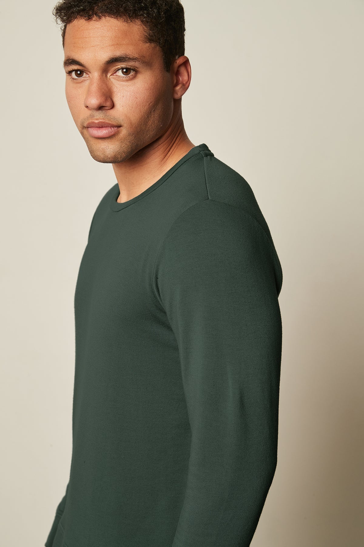   A green long-sleeved SOREN LUXE FLEECE PULLOVER-wearing man in soft and stretch workout Velvet by Graham & Spencer gear. 