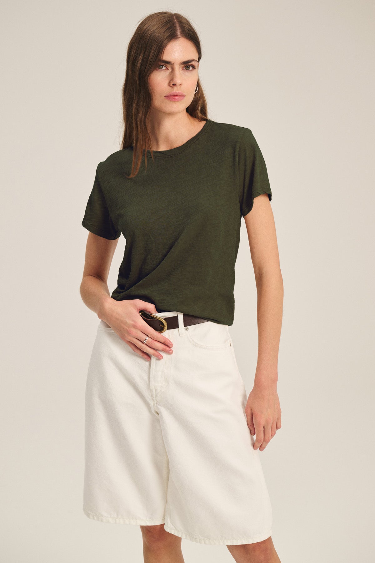 A woman wears a dark green MARIKA TEE by Velvet by Graham & Spencer in cotton slub with white knee-length shorts, facing the camera with a neutral expression to showcase the tee's relaxed, boxy fit.-40825912230081