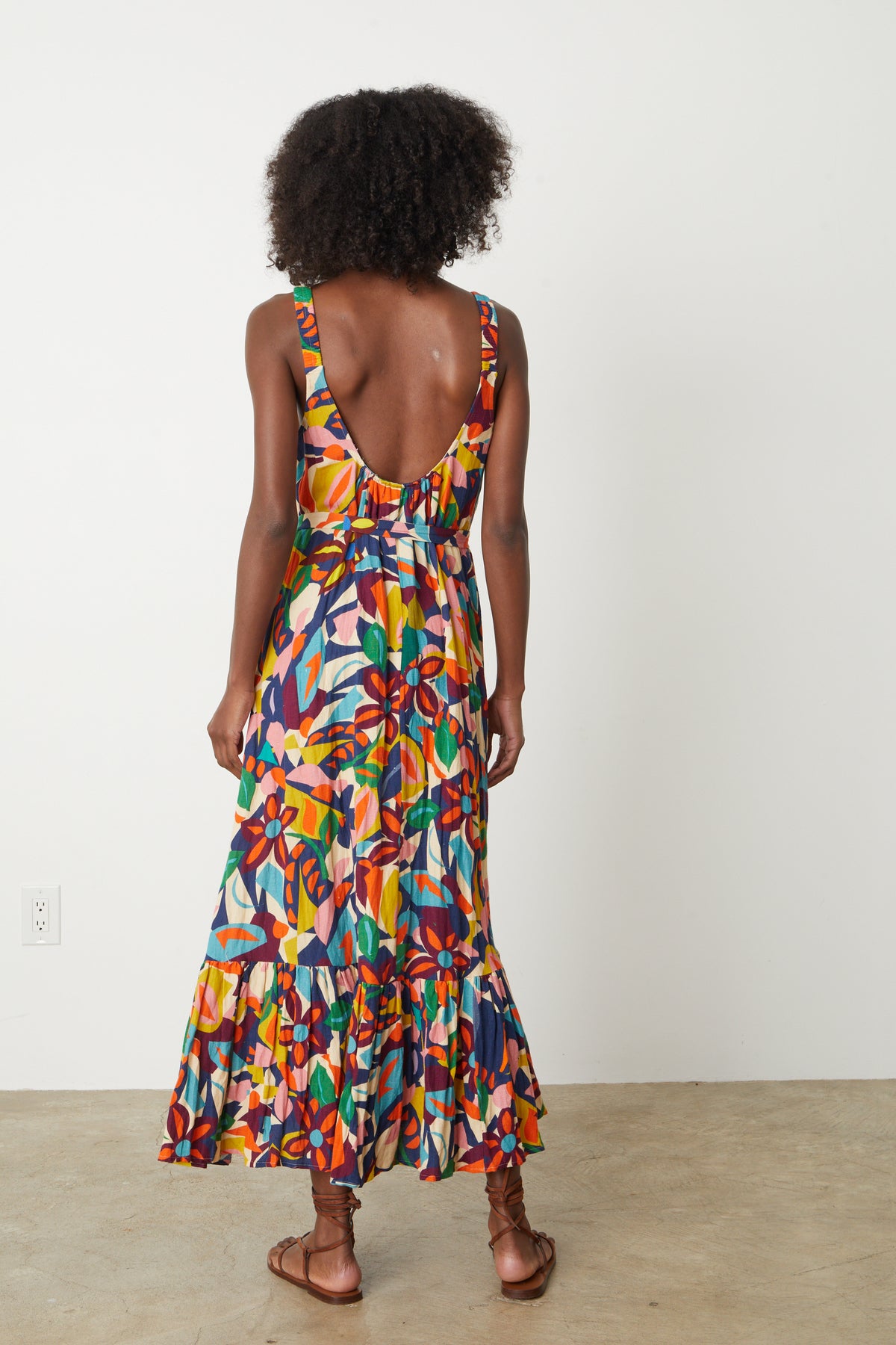 The back view of a woman wearing a ESTELLE PRINTED LINEN DRESS.-26774841753793