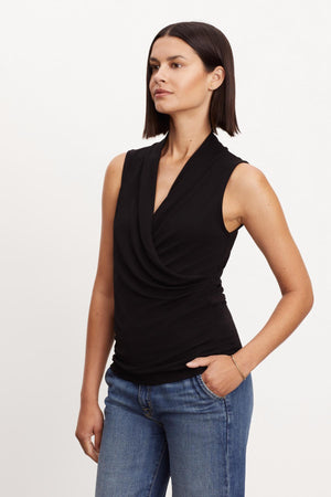 A woman wearing a Velvet by Graham & Spencer Dorthy Wrap Tank Top and jeans.