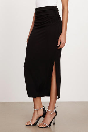 A woman wearing a Hilton maxi skirt by Velvet by Graham & Spencer with a slit.