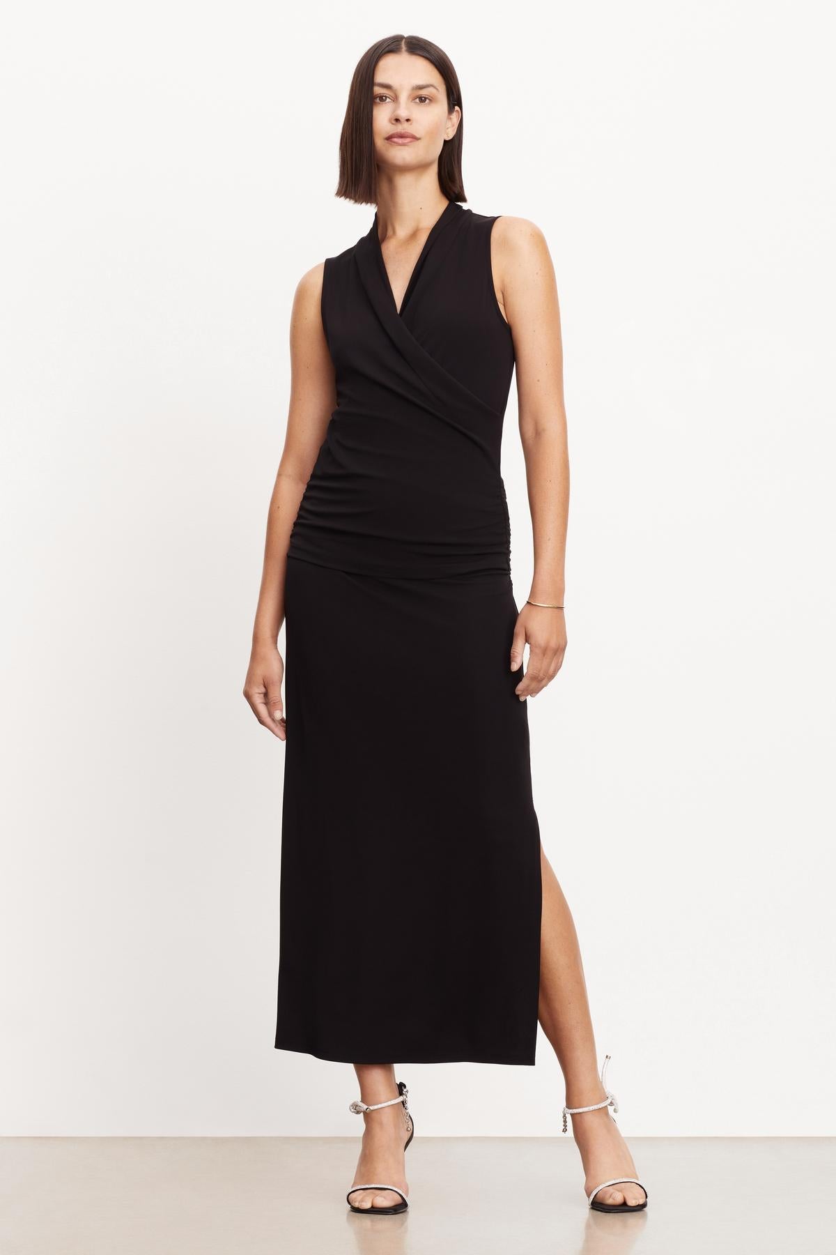   A woman wearing a Velvet by Graham & Spencer sleeveless dress with a slit. 