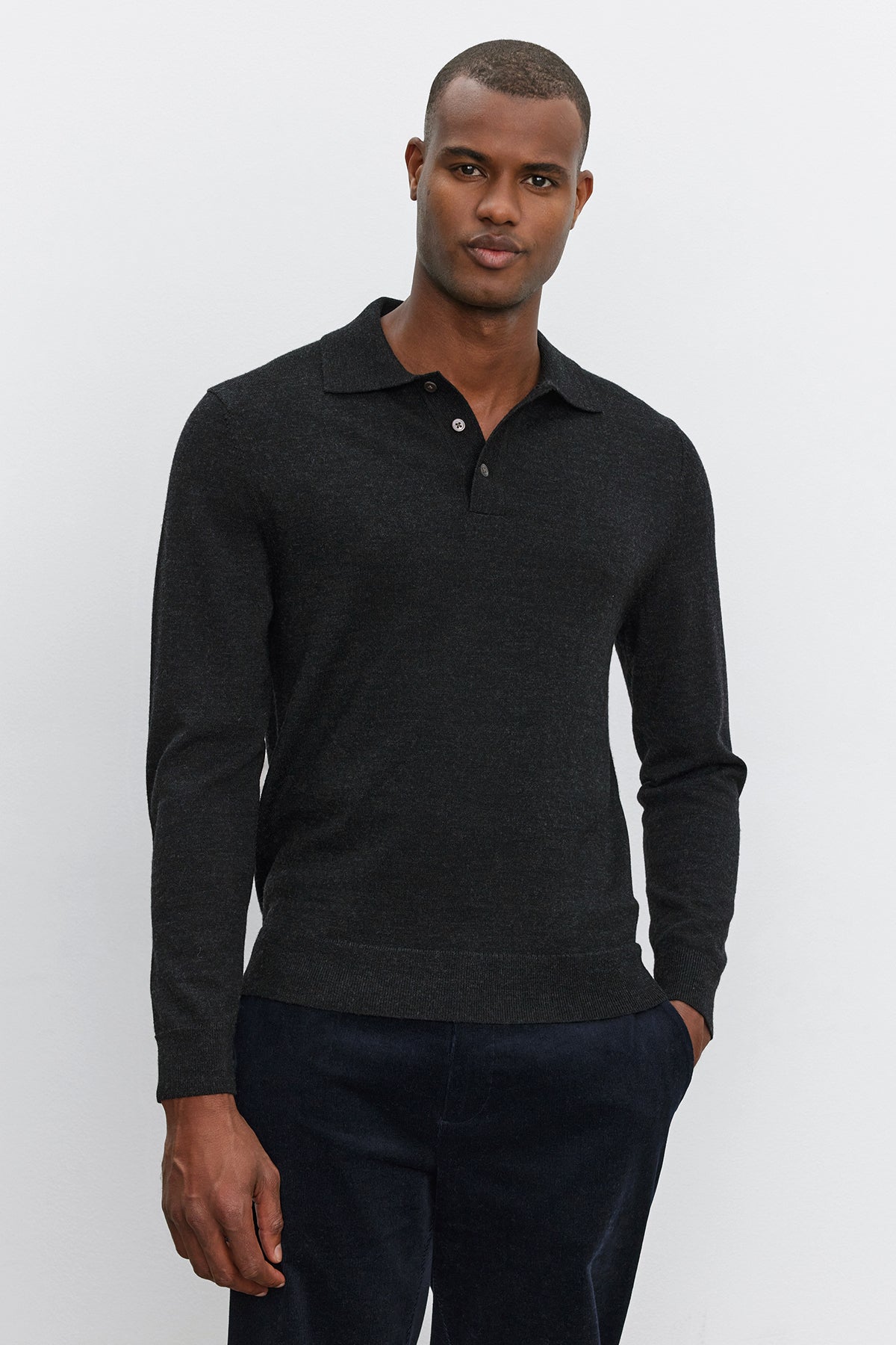   A man wearing the ARTHUR SWEATER POLO by Velvet by Graham & Spencer and dark pants stands against a plain white background. 