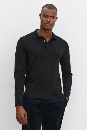 A man wearing the ARTHUR SWEATER POLO by Velvet by Graham & Spencer and dark pants stands against a plain white background.