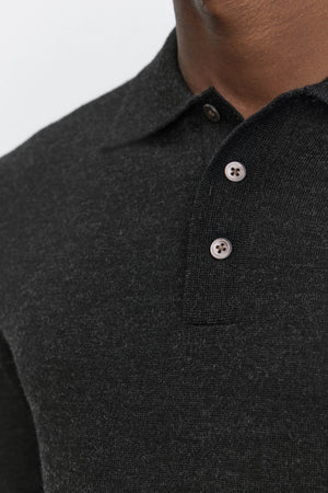 Close-up of a person wearing the ARTHUR SWEATER POLO from Velvet by Graham & Spencer. This dark grey merino wool collared shirt features a three-button placket, with the top button unfastened, showcasing its classic design.