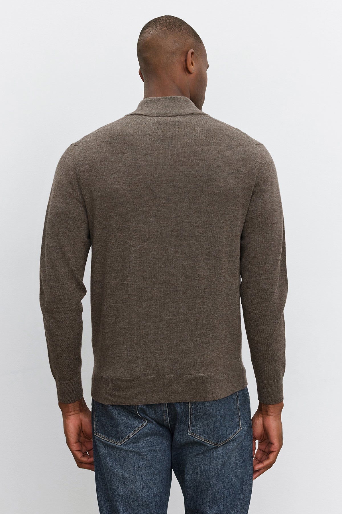 A person wearing a FLETCHER QUARTER-ZIP SWEATER in brown by Velvet by Graham & Spencer, paired with blue jeans, is shown from the back, standing against a plain white background.-37893888671937