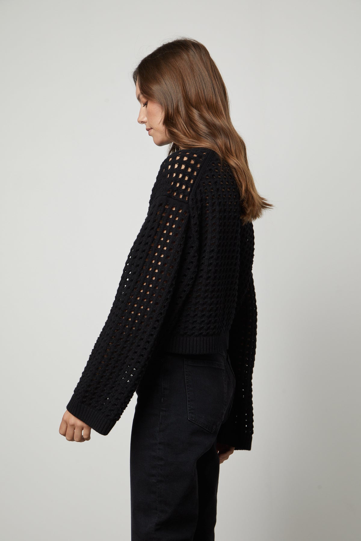 The back view of a woman wearing a Velvet by Graham & Spencer SAMMIE MESH KNIT CREW NECK SWEATER.-26910428692673