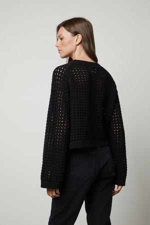 The back view of a woman wearing a Velvet by Graham & Spencer SAMMIE MESH KNIT CREW NECK SWEATER.