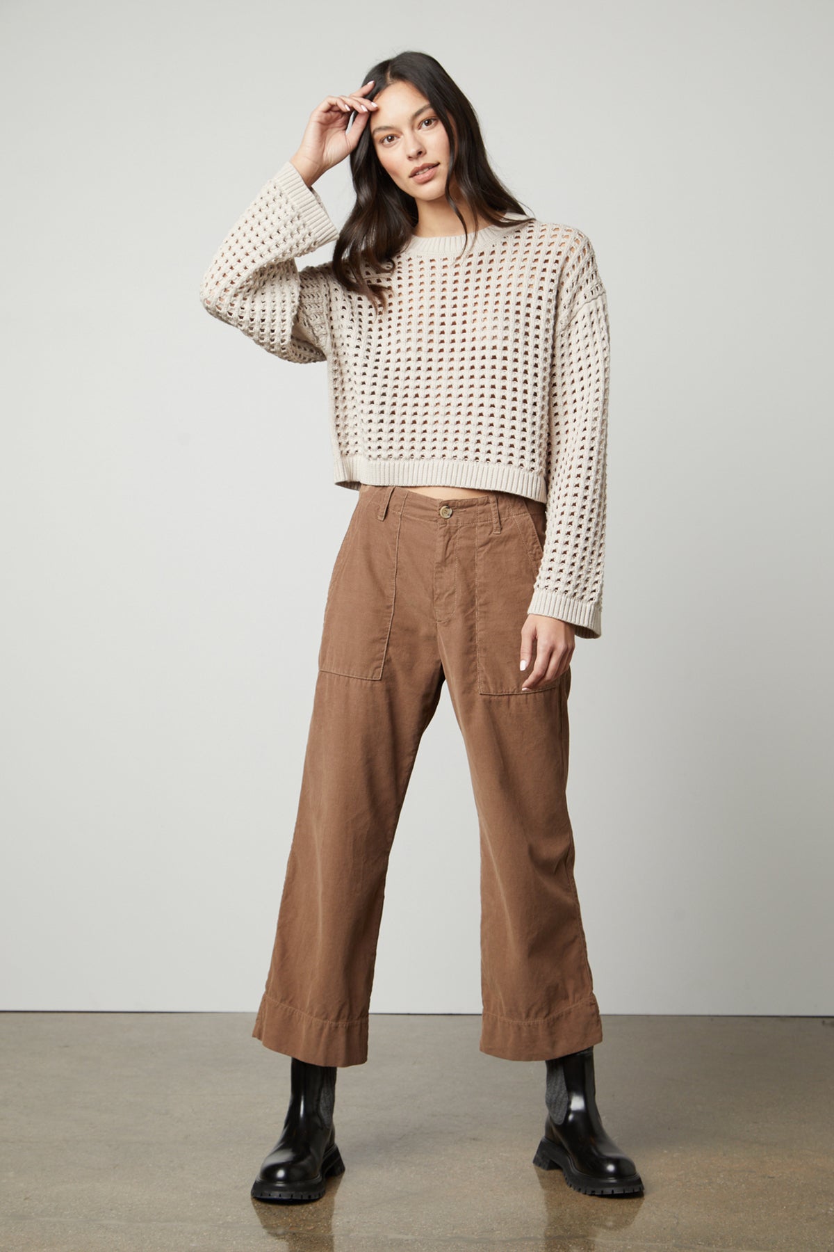 The model is wearing a brown Velvet by Graham & Spencer SAMMIE MESH KNIT CREW NECK SWEATER and cropped pants.-26897858756801