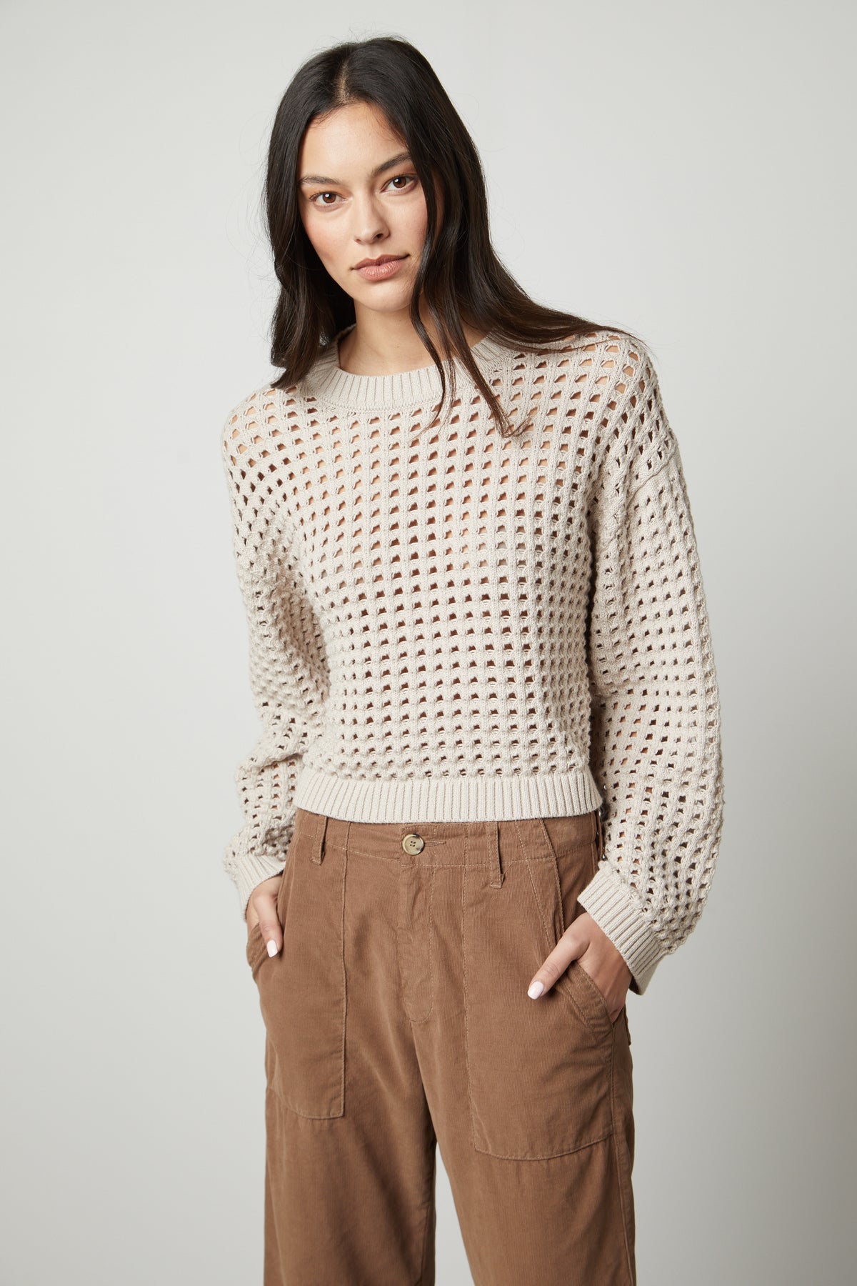 The model is wearing a Velvet by Graham & Spencer SAMMIE MESH KNIT CREW NECK SWEATER and tan trousers.-26897858789569