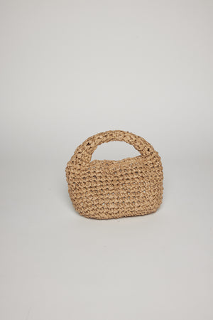 A small, handwoven paper straw MICRO SLOUCH BAG by Velvet by Graham & Spencer with a curved handle, positioned upright against a plain white background.