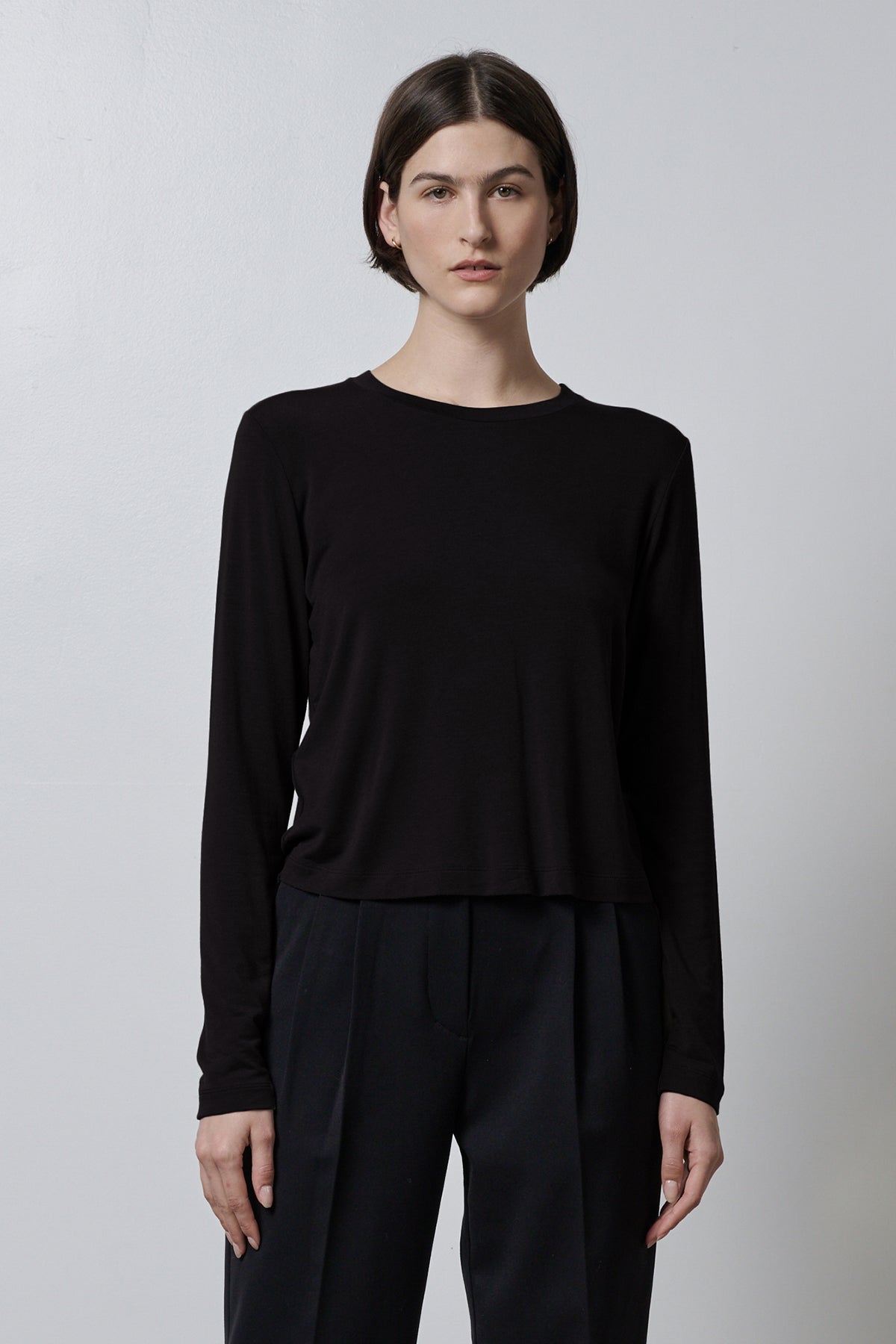 The model is wearing a black Velvet by Jenny Graham rib knit long sleeved top and stretch trousers.-35416710086849