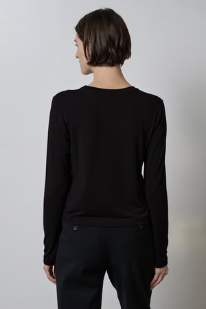 A woman wearing a black rib knit PACIFICA TEE by Velvet by Jenny Graham and slim-fitting black pants is seen from the back view.