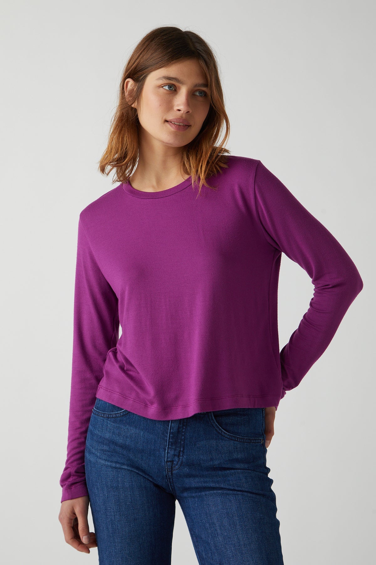 A woman wearing a Velvet by Jenny Graham purple rib knit long-sleeved Pacifica tee and stretch jeans.-26413773914305