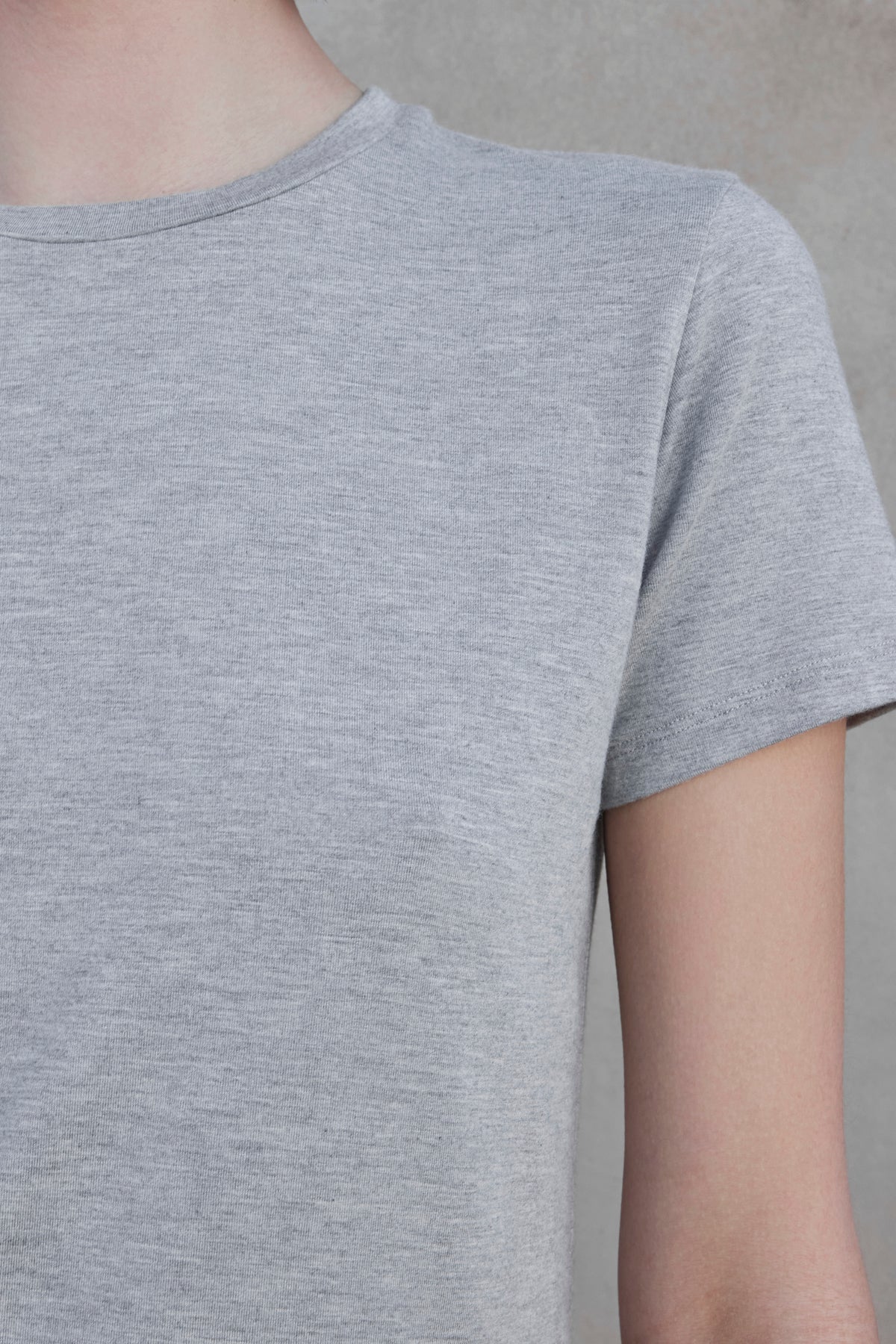   Close-up of a person wearing a Velvet by Jenny Graham light gray SOLANA TEE, crafted from soft modal jersey, set against a neutral background. 