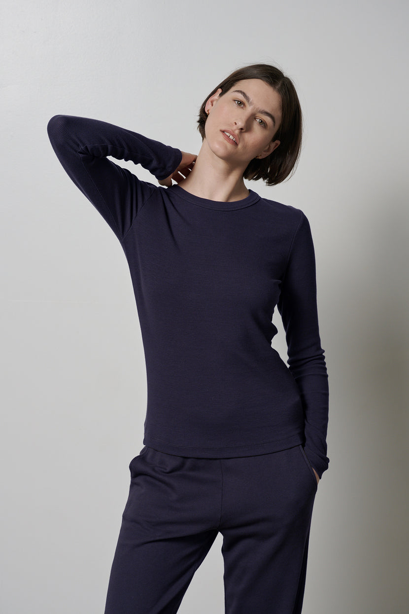 The model is wearing a super soft navy long-sleeved CAMINO TEE and pants that offer ultimate comfort by Velvet by Jenny Graham.