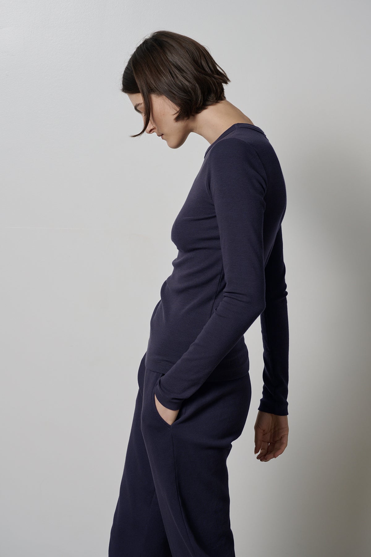   The model is wearing a navy long-sleeved CAMINO TEE and pants by Velvet by Jenny Graham, offering ultimate comfort. 