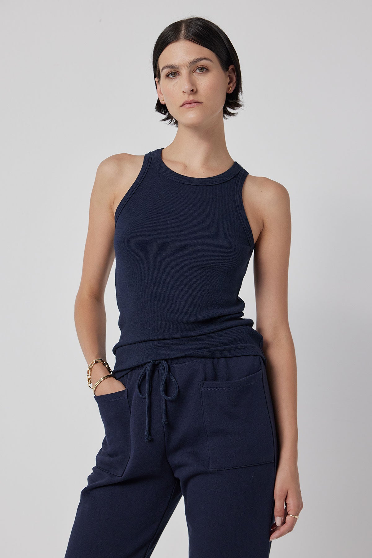   The model is wearing a navy CRUZ tank top and stretch sweatpants by Velvet by Jenny Graham. 