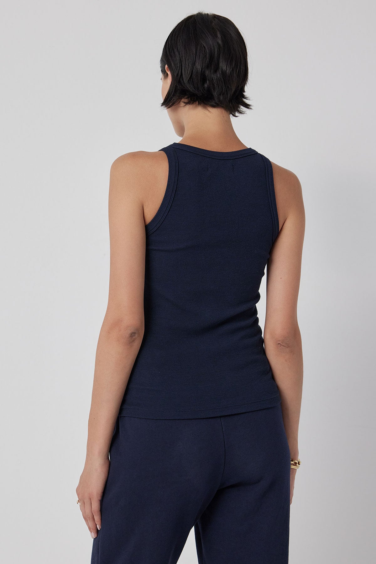 The back view of a woman wearing navy stretch pants and a Velvet by Jenny Graham CRUZ tank top.-36212441219265