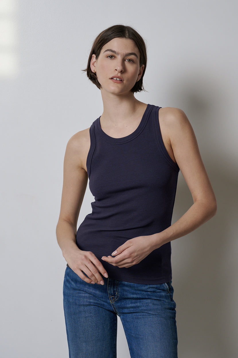 A woman wearing stretch jeans and a fitted Navy Velvet by Jenny Graham Cruz tank top.