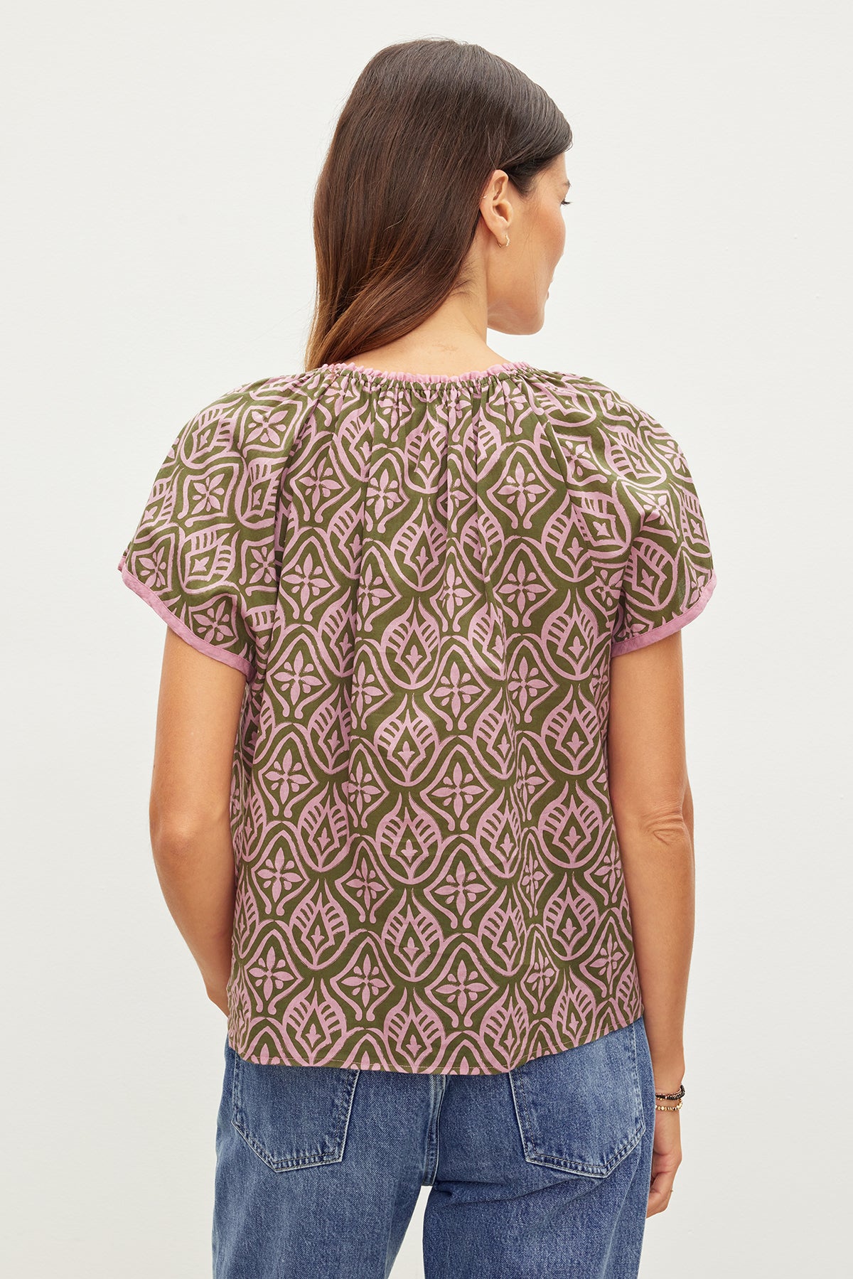 The back view of a woman wearing an IDA printed boho top by Velvet by Graham & Spencer, with raglan short sleeves and ruffle detail.-35967654297793