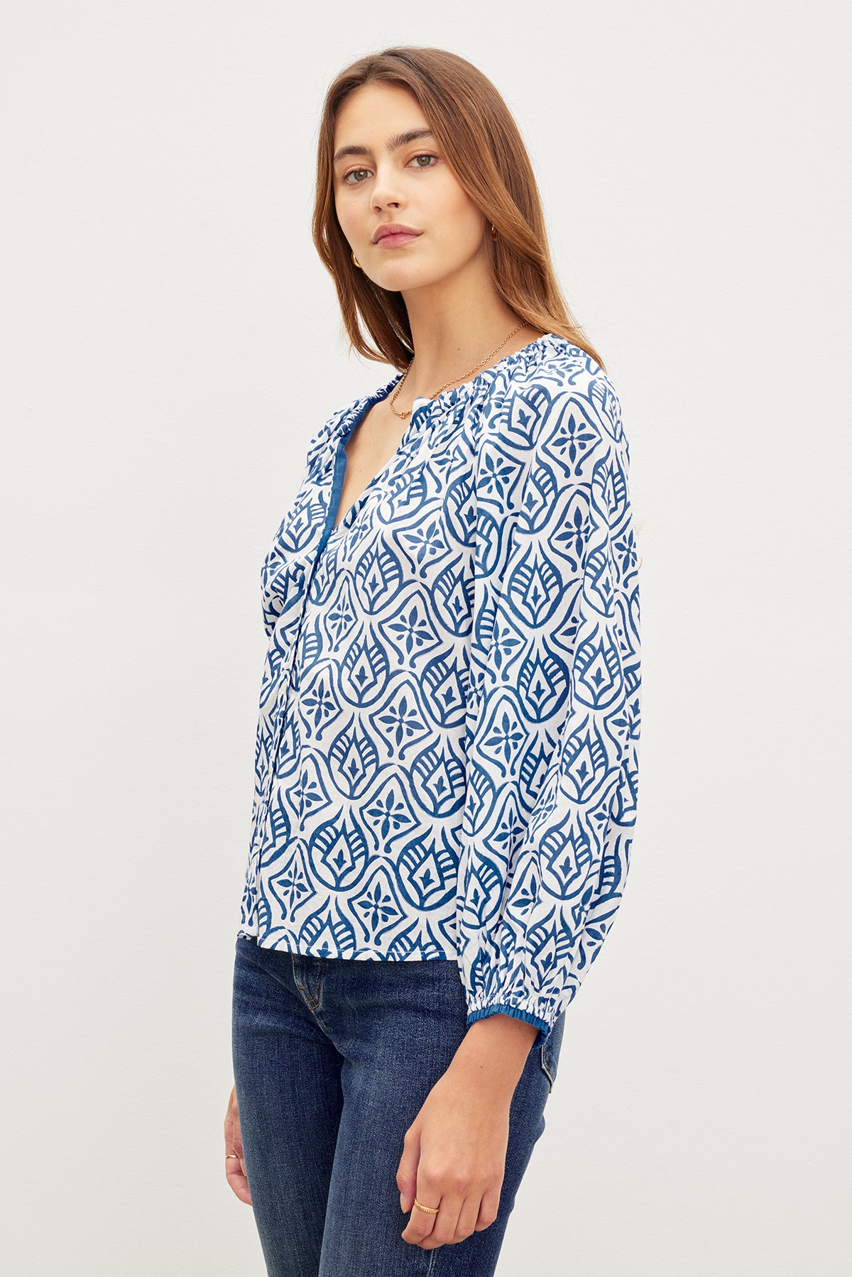 A woman wearing jeans and a MARIAN PRINTED BUTTON FRONT TOP with a v-neckline, by Velvet by Graham & Spencer.-35967584207041