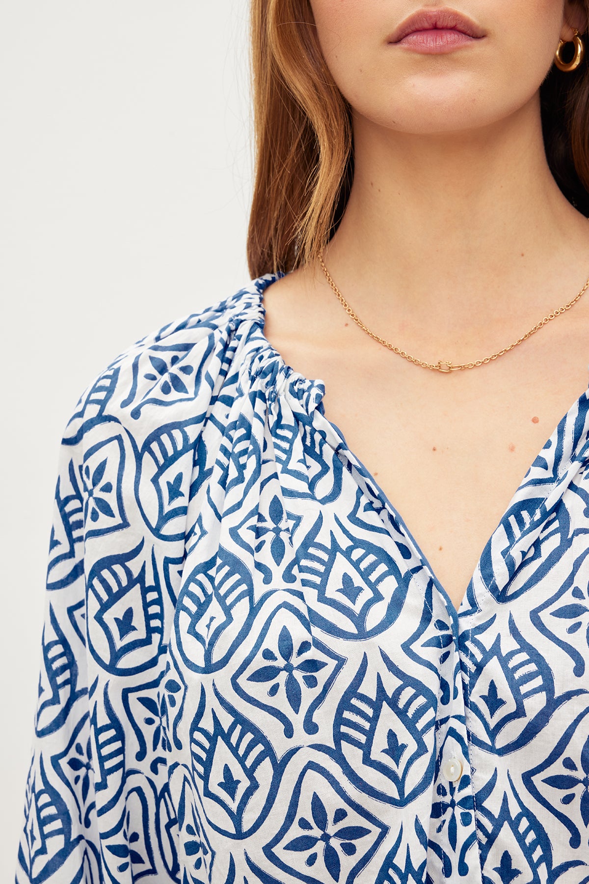   A woman wearing a Velvet by Graham & Spencer Marian Printed Button Front Top in a blue and white mosaic printed cotton fabric. 